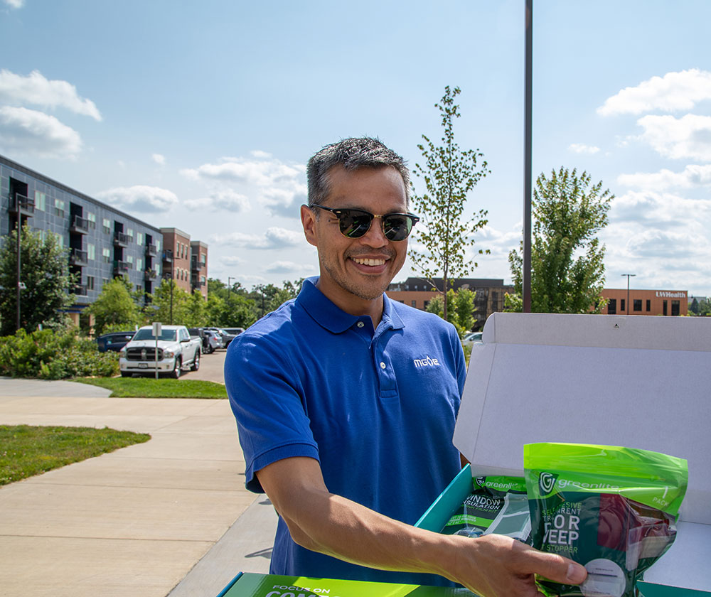 MGE employee handing out energy-efficiency packs at a community event.