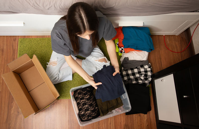 College student packing up clothes to move