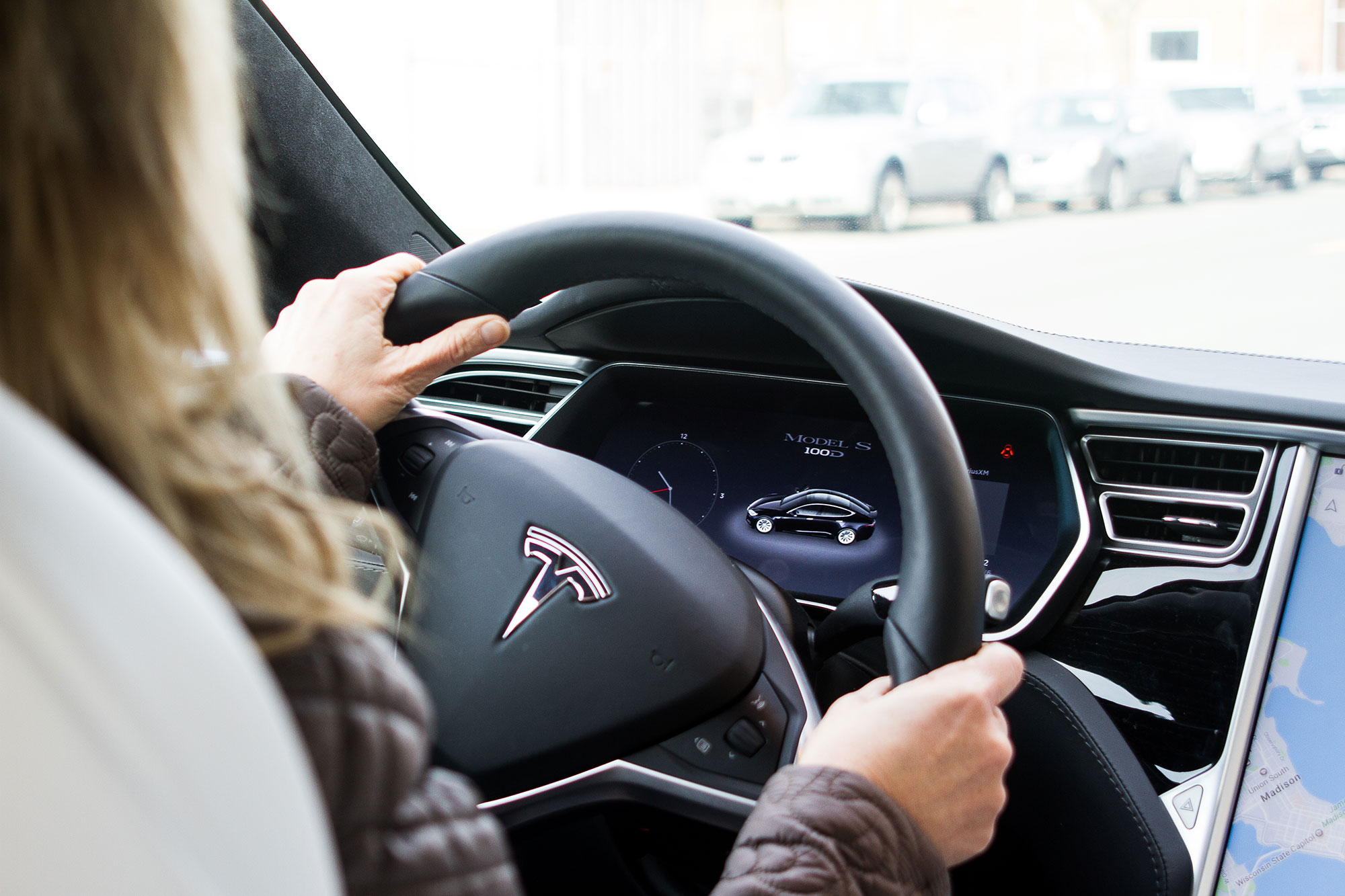 Woman driving a Tesla EV.