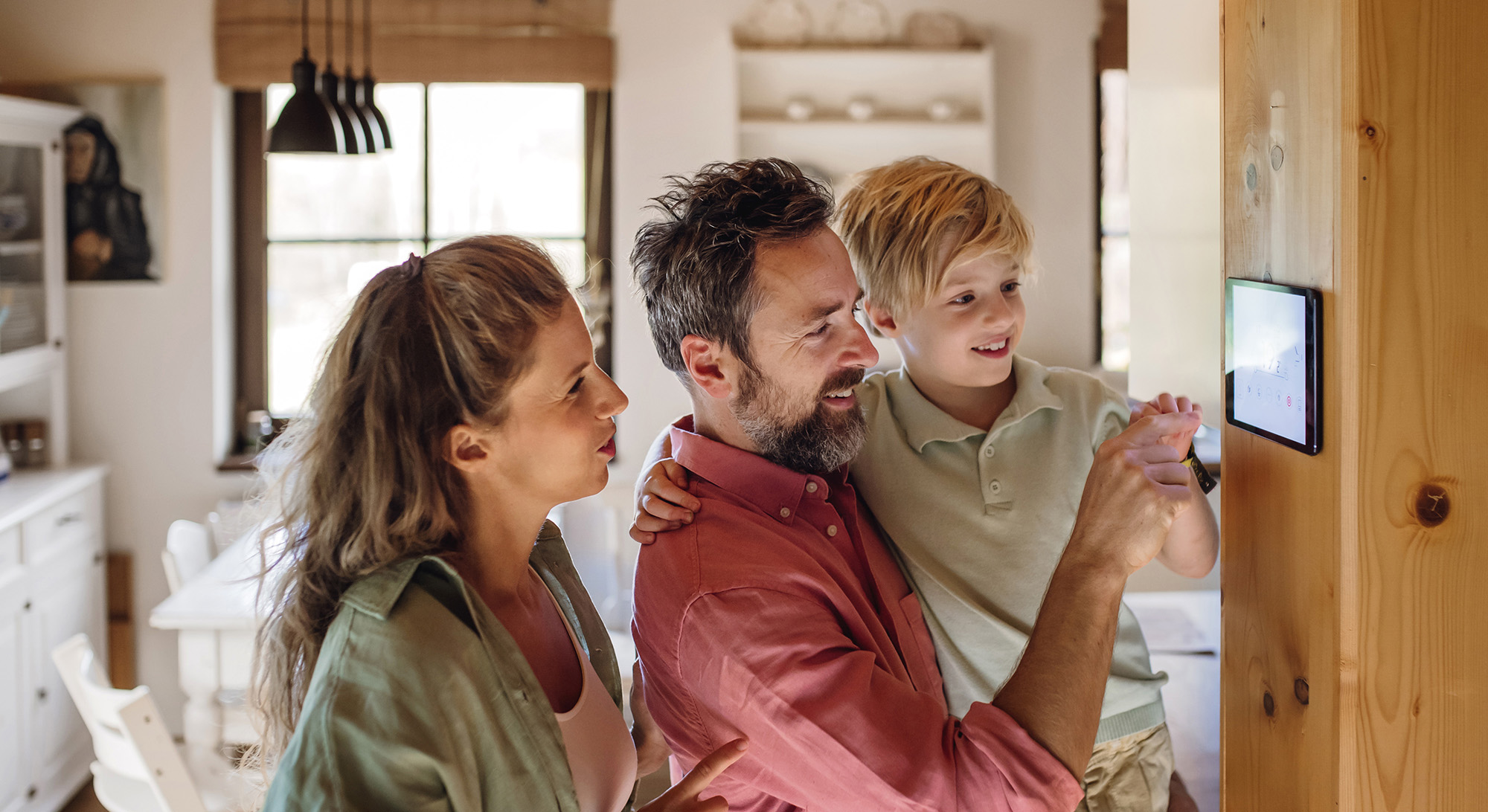 Family looking at smart thermostat.