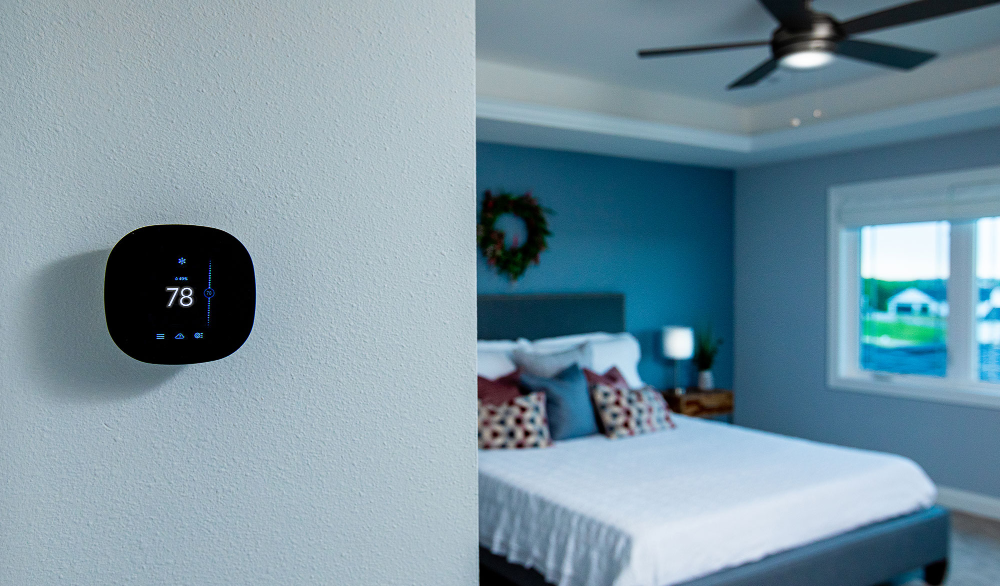 Smart thermostat on a wall in a home.