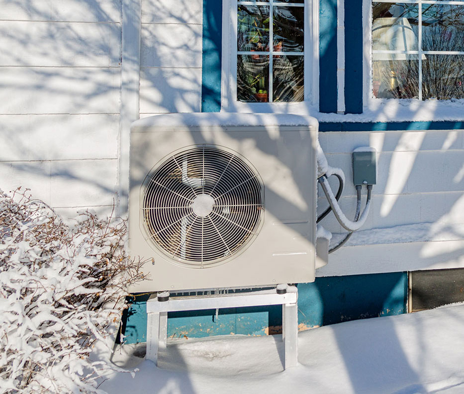 Heat pump outside of a home in winter.