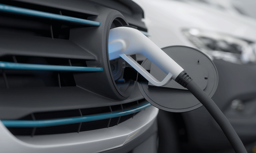 A closeup of a charger plugged into an electric vehicle.